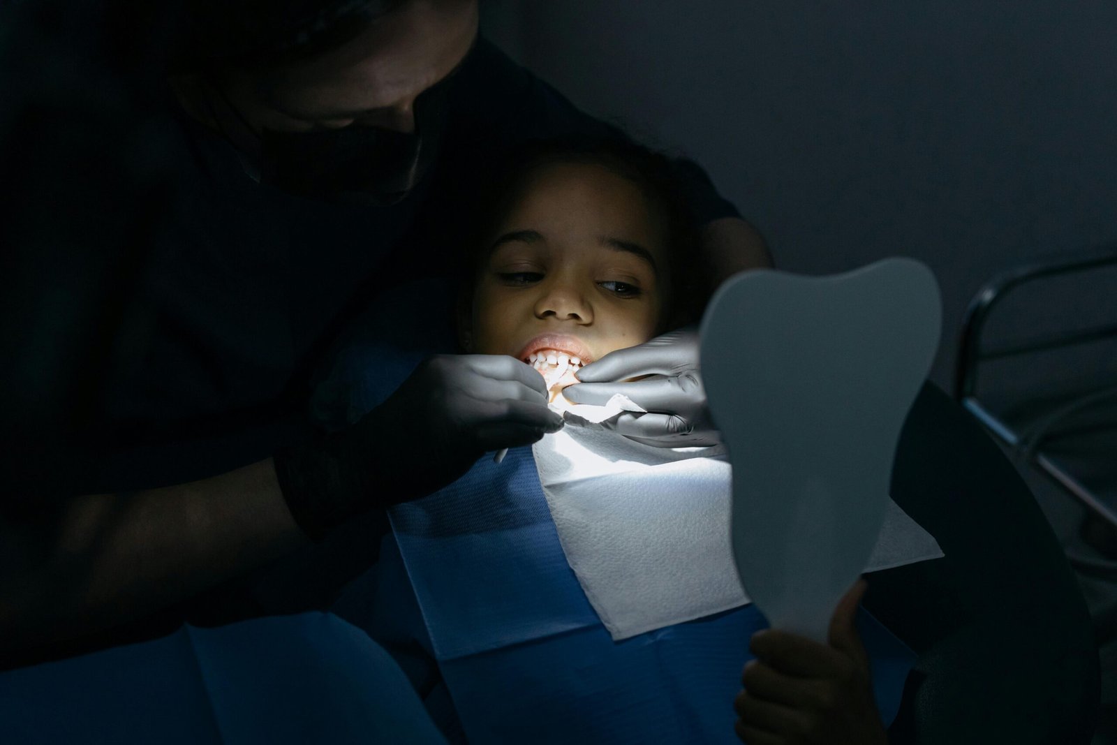 A child receives a dental checkup at a clinic, highlighting oral health care.